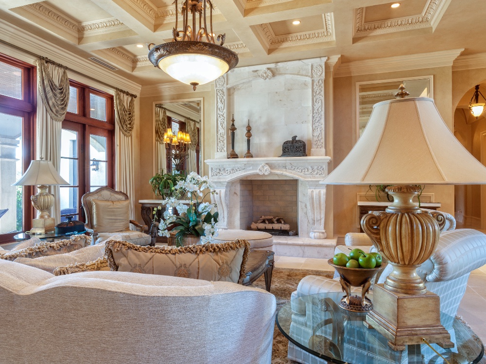 Grand living room with carved limestone fireplace and coffered ceiling